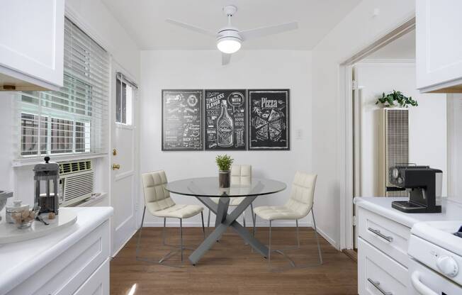 a kitchen with a table and chairs and a chalkboard on the wall