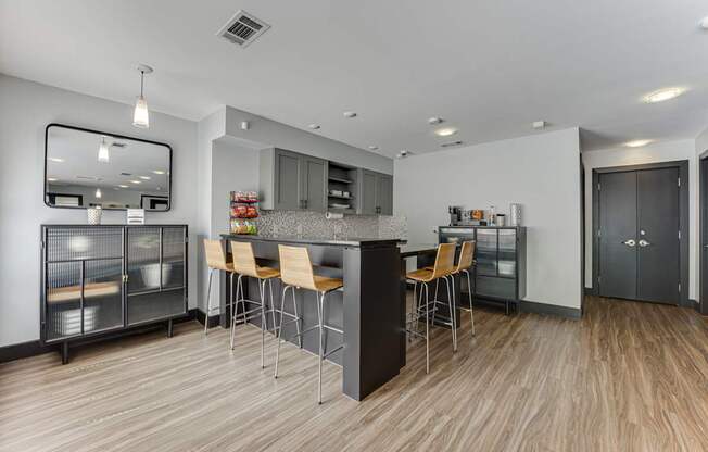 A modern kitchen with a wooden floor and a large island with chairs.