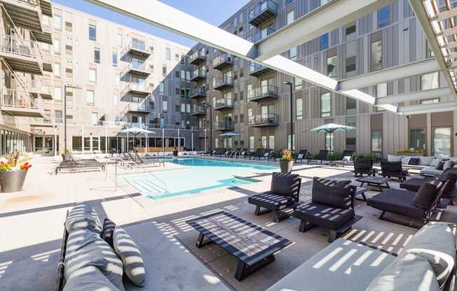 A large outdoor pool area with lounge chairs and umbrellas.