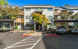 A parking lot with cars and apartment buildings in the background.