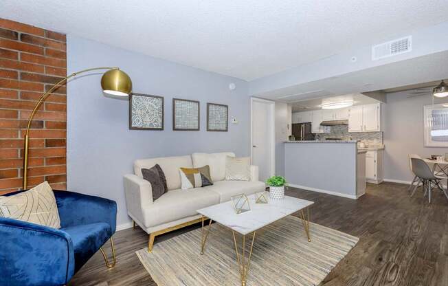 A living room with a blue chair and a white couch.