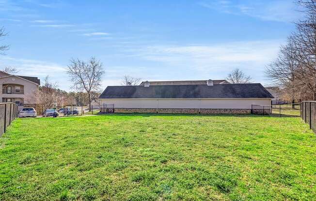 A large grassy field with a building in the background.
