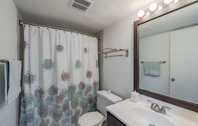 a bathroom with a shower and a sink and a toilet