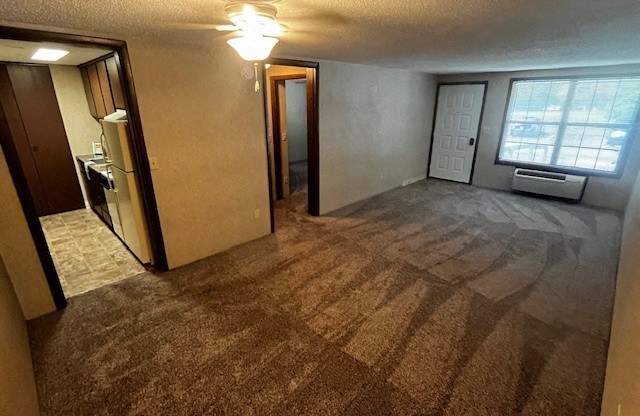 an empty living room with a door and a window