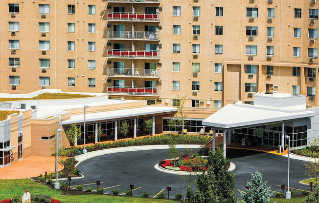 A large building with a green roof and a white covered walkway at Hummingbird Pointe & The Gardens, Parma, 44129