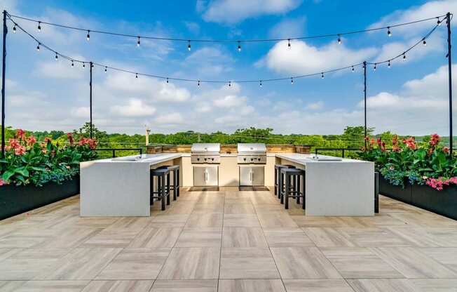 A modern outdoor kitchen with a bar area and seating.