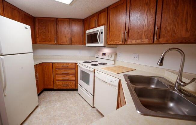 a kitchen with a white stove top oven next to a sink