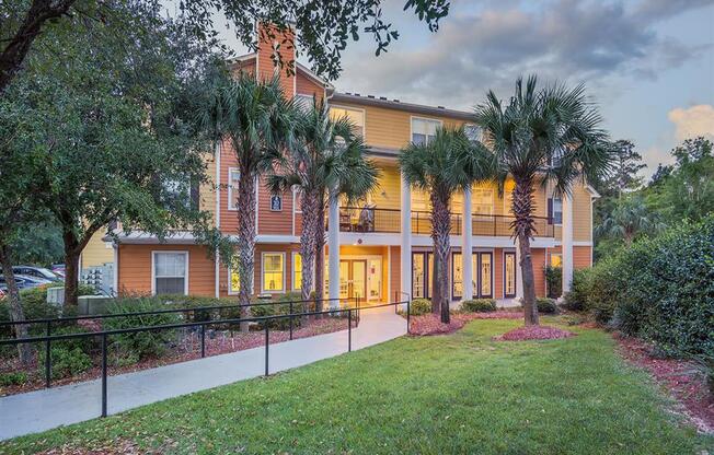 Tallahassee FL apartment complex walkway with black railing and lush landscaping through Evergreens at Mahan