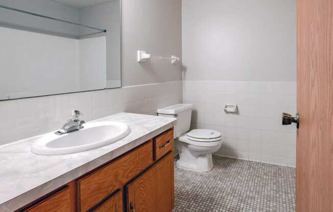 an empty bathroom with a sink toilet and mirror