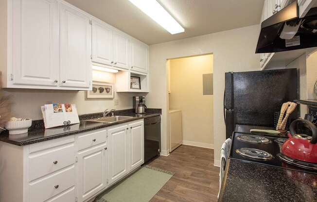 A kitchen with white cabinets and a black stove top at Zinfandel Village Apartments, California, 95670
