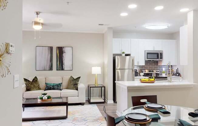 A modern kitchen and living room with a dining table set for two.