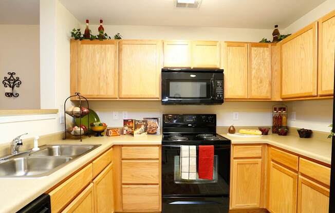 A kitchen with wooden cabinets and a black oven.