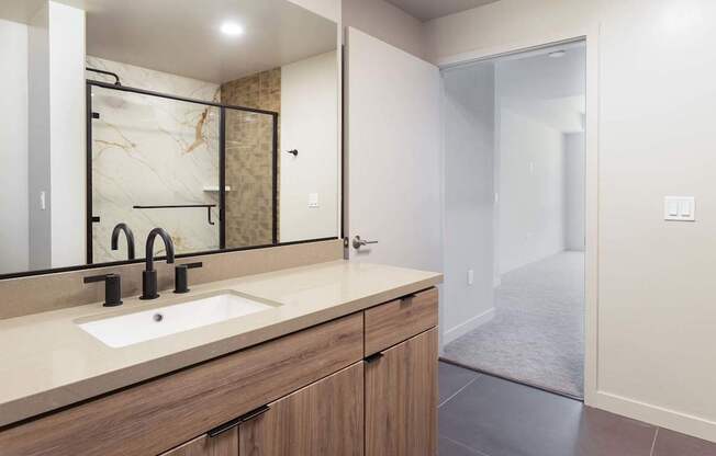 A bathroom with a sink and mirror. at Elements Apartments*, California