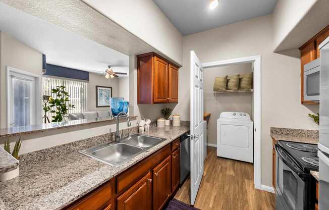 A kitchen with a sink, refrigerator, and oven.