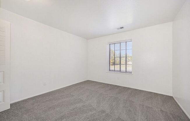 spacious bedroom with a window at Hampton Lakes Apartments, Michigan, 49534