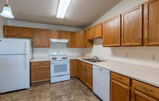 a kitchen with white appliances and wooden cabinets.  Fargo, ND Sunwood Apartments  | Living and kitchen Fargo, ND Sunwood Apartments