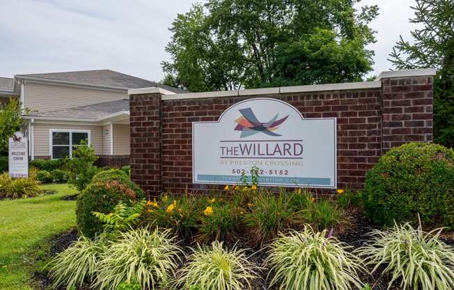 the willard neighborhood entrance sign in front of a brick wall
