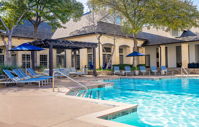 a swimming pool with lounge chairs  and umbrellas