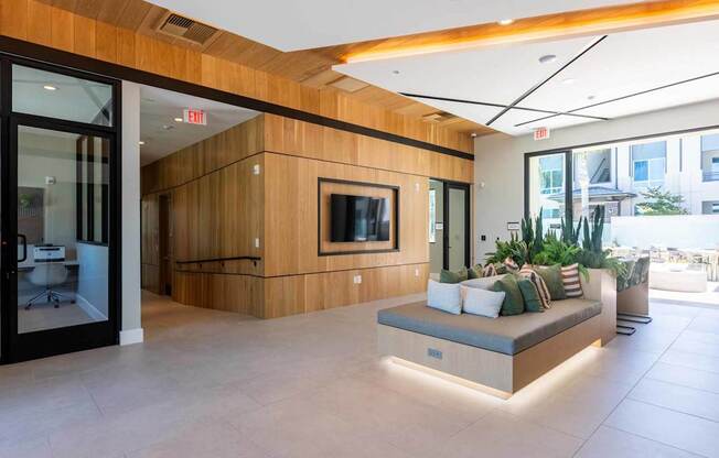 A modern living room with a wooden accent wall and a flat screen TV.