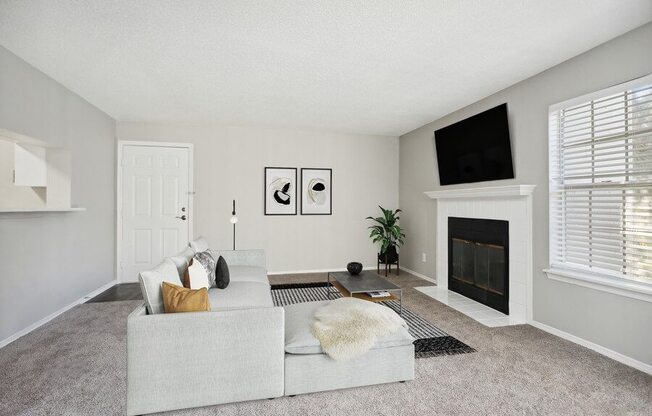 Model Living Room with Front Door and a Fireplace at Caribbean Breeze Apartments in Tampa, FL.
