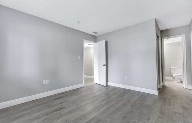 an empty living room with white walls and wood flooring