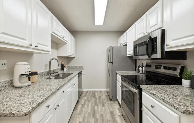 Model kitchen with granite countertops and white cabinets