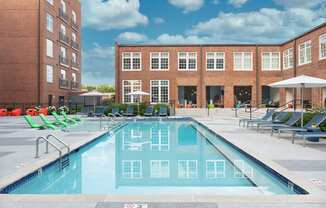 a swimming pool with lounge chairs in front of a building