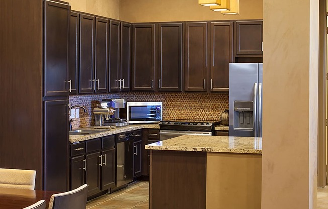 a kitchen with dark cabinets and granite countertops