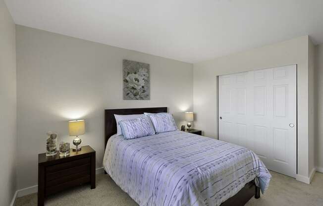 a bedroom with a bed and two night stands at Campo Basso Apartment Homes, Washington, 98087