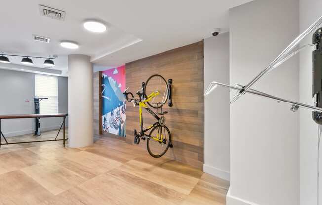 a bike is hanging on a wall in a room with wood floors and a wall