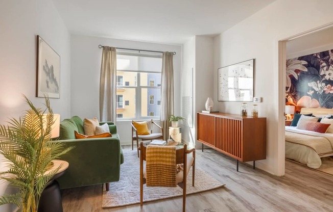 Model living room with a lot of pillows and chairs and a window