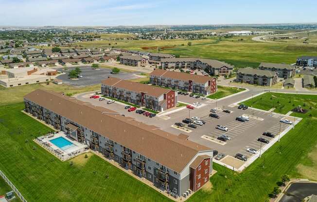 an aerial view of an apartment complex with cars parked in a parking lot