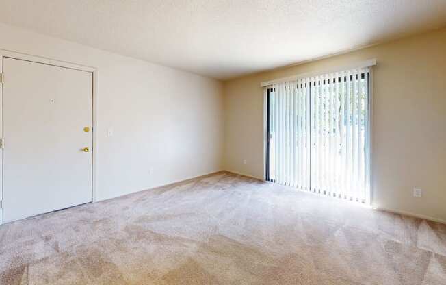 an empty living room with a door to a closet