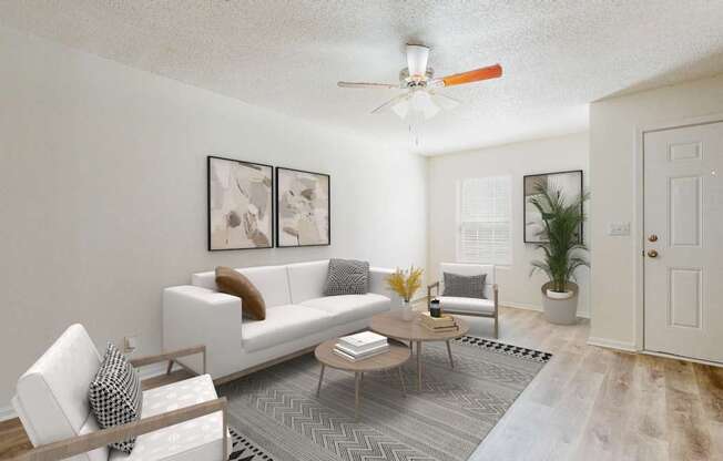 A living room with a white couch, a wooden coffee table, and a ceiling fan.