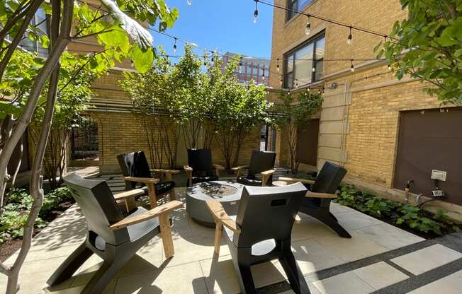 a courtyard with tables and chairs and a fire pit