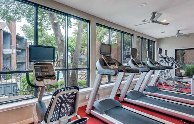 A gym with treadmills and exercise bikes is shown.