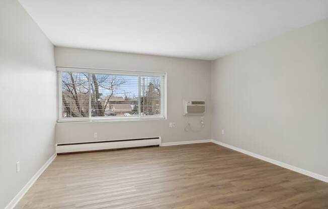 A room with a window and a wall-mounted air conditioner unit.
