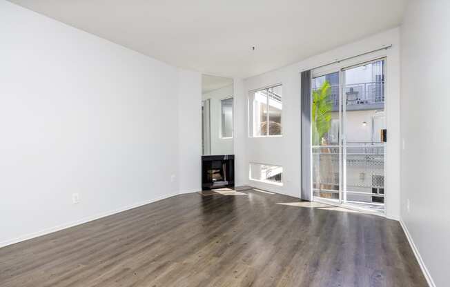 a living room with hardwood floors and a door to a balcony