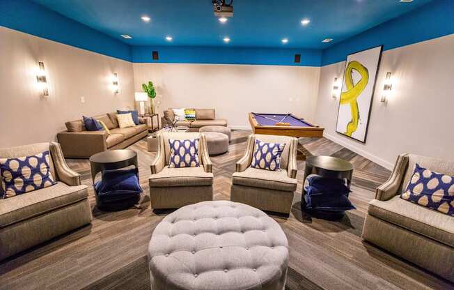 A room with a pool table and comfortable seating.