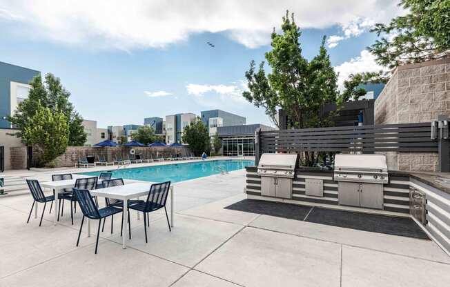 a swimming pool with a table and chairs next to it