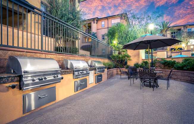 A patio with a table and chairs and a grill.