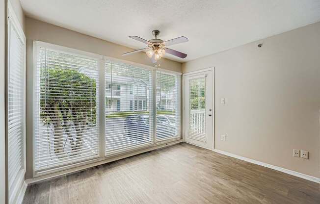 A room with a ceiling fan and sliding glass doors.