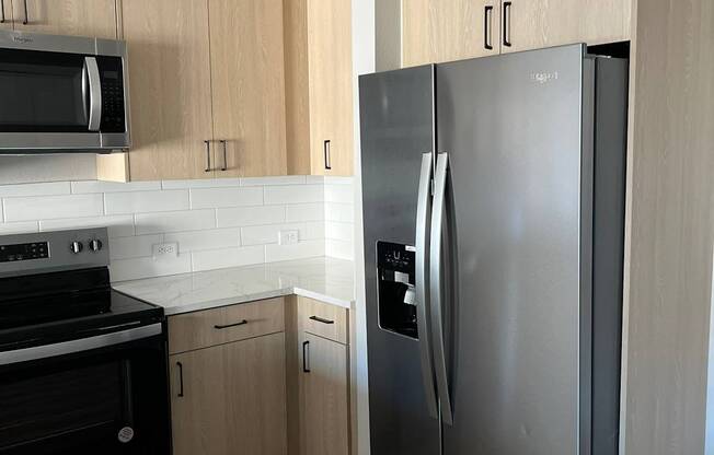 a kitchen with a stainless steel refrigerator