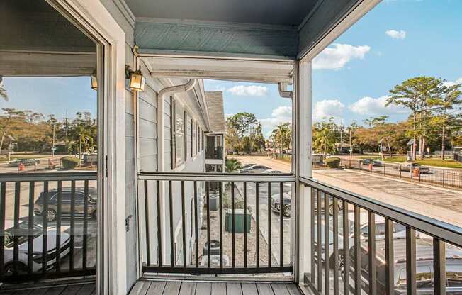 A view from a porch looking out at a parking lot.