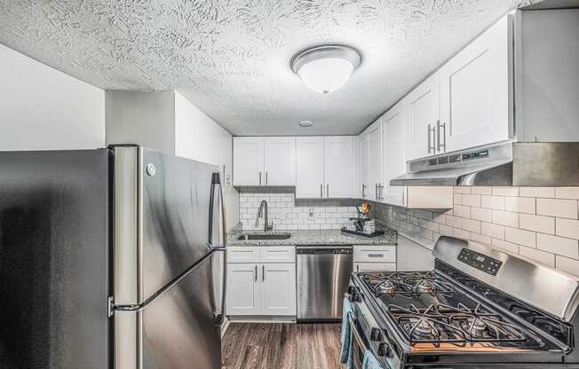 a kitchen with stainless steel appliances and white cabinets