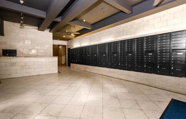 a large locker room in a gym with tile flooring and a white brick wall