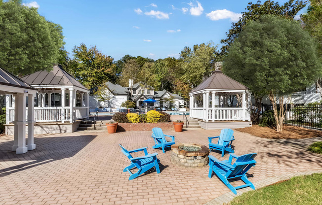 A gazebo surrounded by blue chairs and a brick walkway.