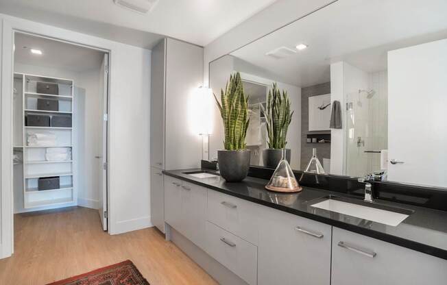 a white and black kitchen with a sink and a mirror