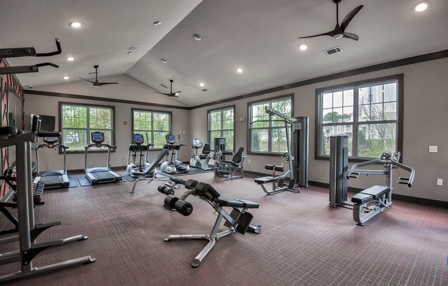 the gym has plenty of exercise equipment and windows