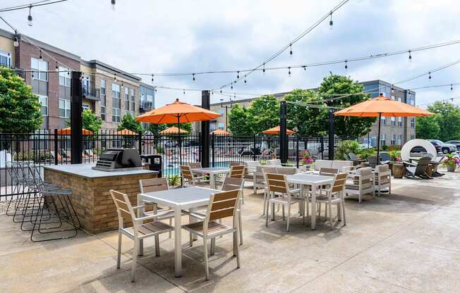 A patio with tables and chairs under orange umbrellas.